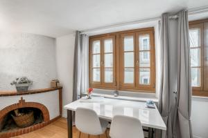 a white dining room with a fireplace and a table and chairs at Boël 3 studio in Geneva