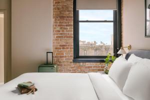 a bedroom with a white bed and a window at LIVN West Loop Chicago Classic Queen Studio in Chicago