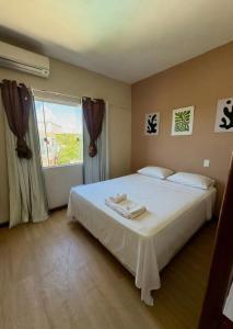 a bedroom with a large white bed with a window at Franz Beach in Nova Viçosa +91 photos