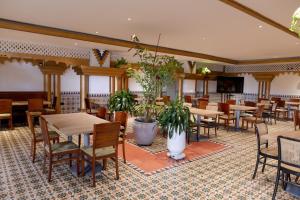 a dining room with tables and chairs and plants at Hotel Faranda Express Puerta Del Sol Barranquilla, A Member of Radisson Individuals in Barranquilla