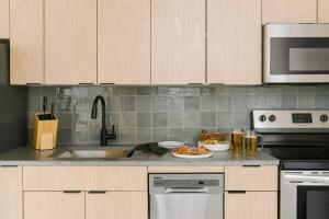 a kitchen with a counter with a sink and a stove at LIVN West Loop Chicago Queen Superior Studio in Chicago