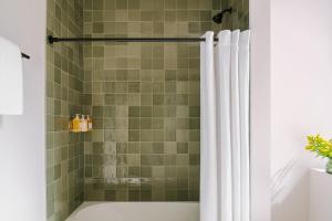 a shower with a white shower curtain in a bathroom at LIVN West Loop Chicago Queen Superior Studio in Chicago