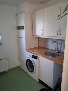 a kitchen with a washing machine and a sink at bekväm villa in Fliseryd +47 photos