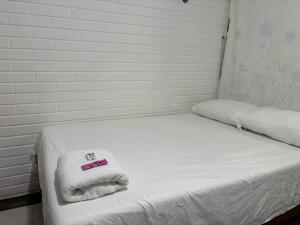 ein weißes Bett mit Handtüchern darauf in der Unterkunft Full studio with parking in Bacalar