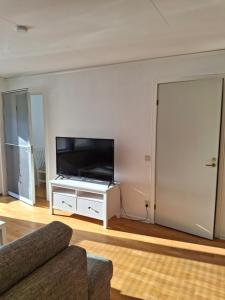 a living room with a flat screen tv on a white entertainment center at bekväm villa in Fliseryd