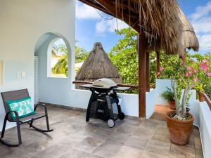 a patio with a wheelbarrow and a table and a chair at Casa Sonoma - Charming Condos Minutes from Beach & Reef in Puerto Morelos