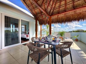 a dining room with a table and chairs on a patio at Casa Sonoma - Charming Condos Minutes from Beach & Reef in Puerto Morelos