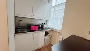 a small kitchen with a sink and a microwave at Soho China Town Rooms in London