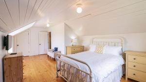 a bedroom with a white bed and a couch and a tv at Bayview Together Farm by AvantStay in Clinton