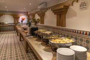 a buffet line with plates and bowls of food at Hotel Faranda Express Puerta Del Sol Barranquilla, A Member of Radisson Individuals in Barranquilla