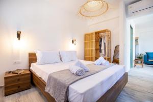 a bedroom with a large bed with white sheets and pillows at East Coast in Alyki