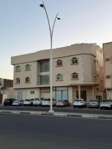 a building with cars parked in a parking lot at شقة فاخرة بجاكوزي وبلياردو دخول ذاتي in Hail