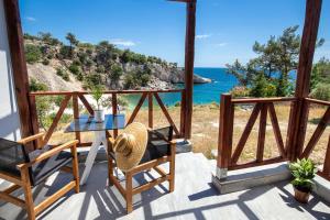 a patio with a table and chairs and the ocean at East Coast in Alyki
