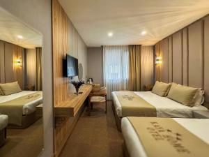 a hotel room with two beds and a television at Kaya Home Otel in Trabzon +64 photos