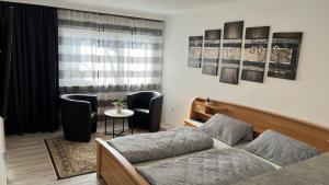 a bedroom with a bed and two chairs and a table at Ferienwohnung Safran 2 in Konz