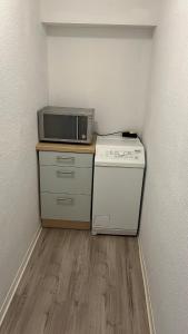 a small kitchen with a microwave and a stove at Ferienwohnung Safran 2 in Konz