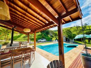 a patio with a table and chairs and a pool at Sítio São Francisco da saudade Refugio Conforto e Afeto na Serra de Cunha a 200m do asfalto in Cunha