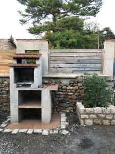 a stone oven sitting next to a stone wall at Locéane in Le Pêchereau