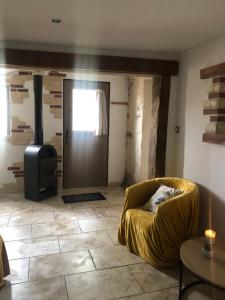 a living room with a yellow couch and a door at Locéane in Le Pêchereau