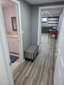 a living room with a ottoman sitting on a hard wood floor at Bright Cozy 2-Bedroom Main Floor Suite in Brampton