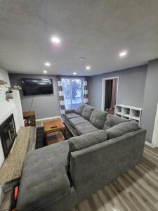 a living room with a large couch and a television at Bright Cozy 2-Bedroom Main Floor Suite in Brampton