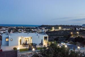 a house with a view of a city at night at Sebastian Villas in Afantou +5 photos