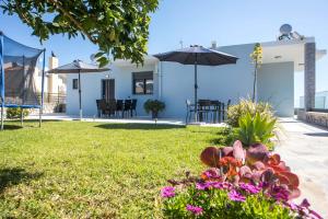 a garden with flowers and an umbrella in a yard at Sebastian Villas in Afantou