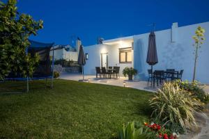 a backyard with a table and chairs and an umbrella at Sebastian Villas in Afantou