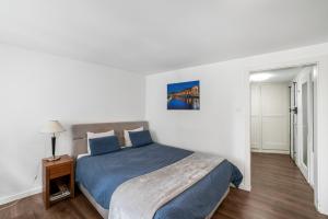 ein Schlafzimmer mit einem Bett mit blauer Tagesdecke in der Unterkunft Boel 4 Studio in Genf