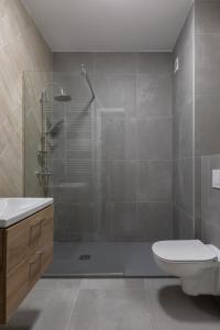 a bathroom with a shower and a toilet and a sink at The Aristocrat by D'or Selection in Bucharest