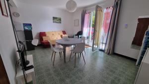 a living room with a table and chairs and a couch at T2Leucate La Franqui Calme Mer Clim Parking P in Leucate
