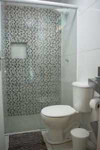 a bathroom with a toilet and a glass shower at Hermoso Apartamento, Centro de Búzios-5Min da Orla in Búzios +33 photos