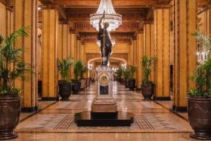 a hallway with a clock in the middle of a building at The Roosevelt Hotel New Orleans - Waldorf Astoria Hotels & Resorts in New Orleans +103 photos