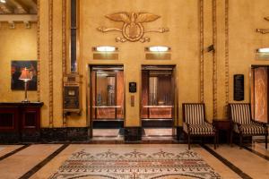 a hallway with two chairs and a rug in a building at The Roosevelt Hotel New Orleans - Waldorf Astoria Hotels & Resorts in New Orleans