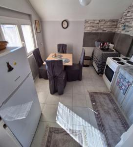 a kitchen with a table and a refrigerator and a stove at Dvosoban stan in Užice