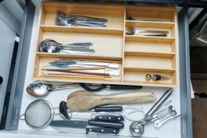 a drawer full of kitchen utensils in a cabinet at Kris Comfort Garden Suite in Edmonton