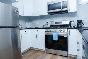 a white kitchen with a stove and a microwave at Kris Comfort Garden Suite in Edmonton +23 photos