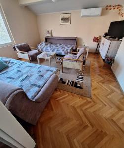 a living room with a bed and a couch at Dvosoban stan in Užice +2 photos