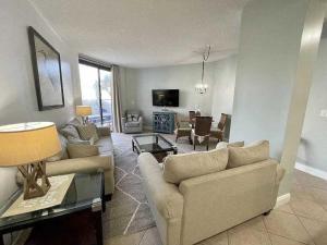 a living room with two couches and a tv at Charming condo with shared pool Gym and Tennis in Destin