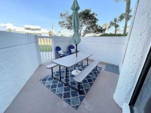 a patio with a table and an umbrella at Charming condo with shared pool Gym and Tennis in Destin