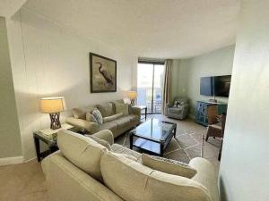 a living room with two couches and a tv at Charming condo with shared pool Gym and Tennis in Destin +15 photos