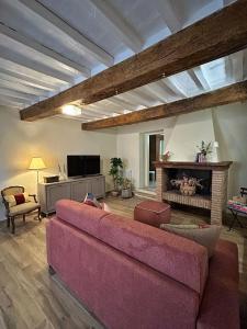 a living room with a pink couch and a fireplace at Dimore Romeo - La Dimora del Corso in Montecastrilli
