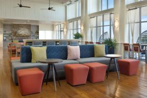 a living room with a couch and some tables and chairs at Hampton Inn & Suites Myrtle Beach Oceanfront in Myrtle Beach +89 photos