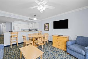 a living room with a table and a couch and a kitchen at Paradise Resort in Myrtle Beach