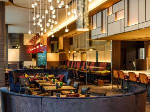 a restaurant with tables and chairs and a chandelier at Pullman Tokyo Tamachi in Tokyo