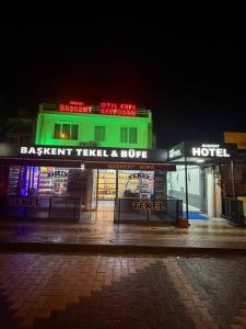 a green building with a hotel on a street at night at Başkent Otel in Mudanya