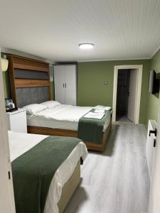 two beds in a room with green walls at Başkent Otel in Mudanya