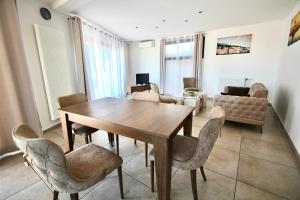 a dining room with a wooden table and chairs at Villa avec vue - terrasse - parking in Irigny