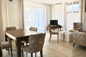 a dining room with a table and chairs and a desk at Villa avec vue - terrasse - parking in Irigny