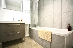 a bathroom with a sink and a bath tub at Villa avec vue - terrasse - parking in Irigny +18 photos